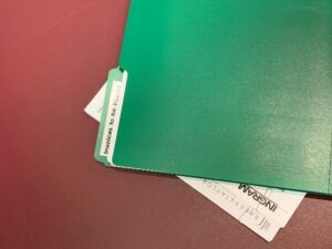 A green folder with invoices inside.