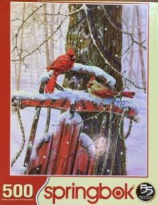 Click this image to place this puzzle of cardinals on a sled in the snow on hold.