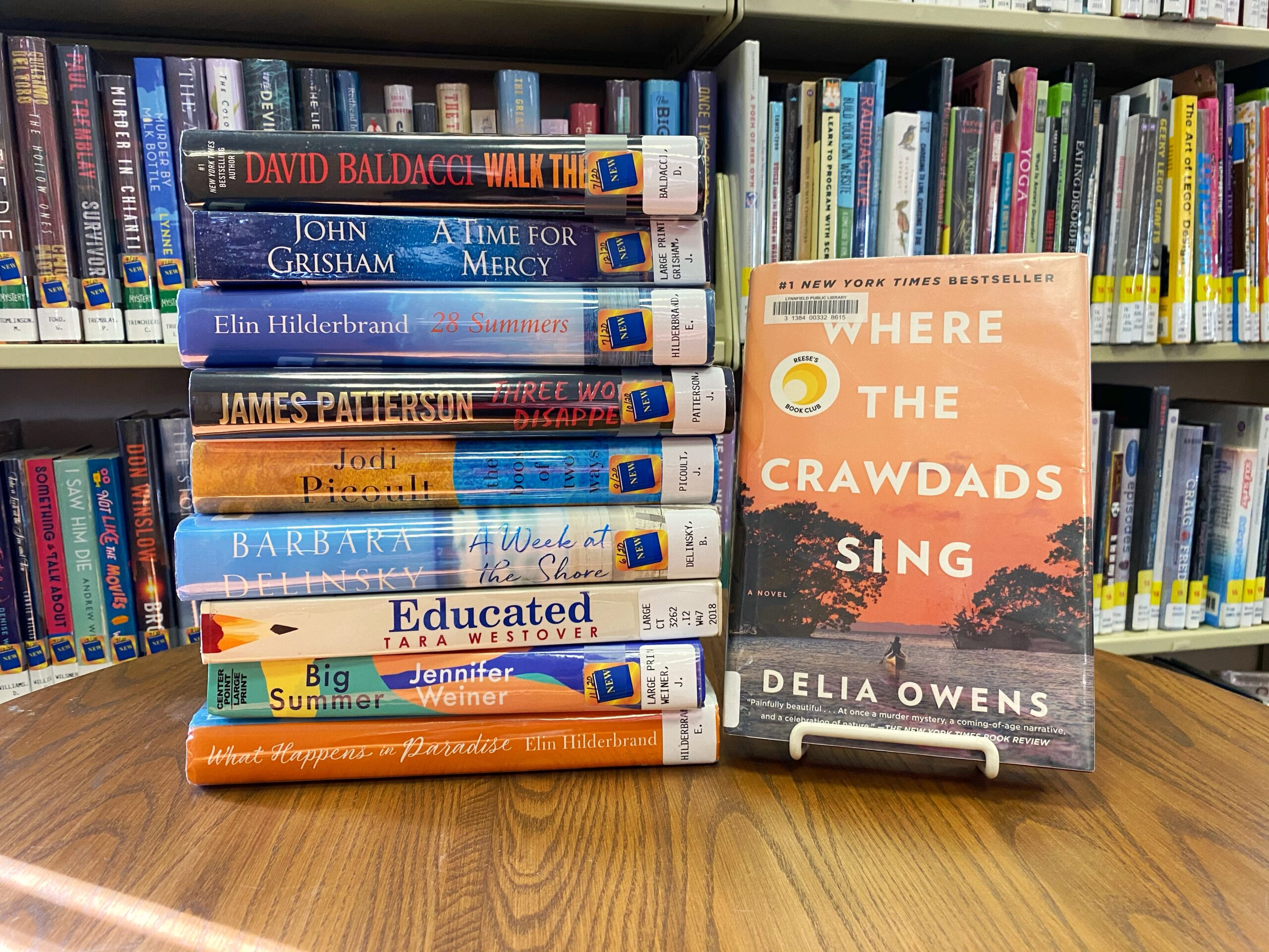 A stack of books from the blog post list on a table. Where the Crawdads Sing faces the camera.